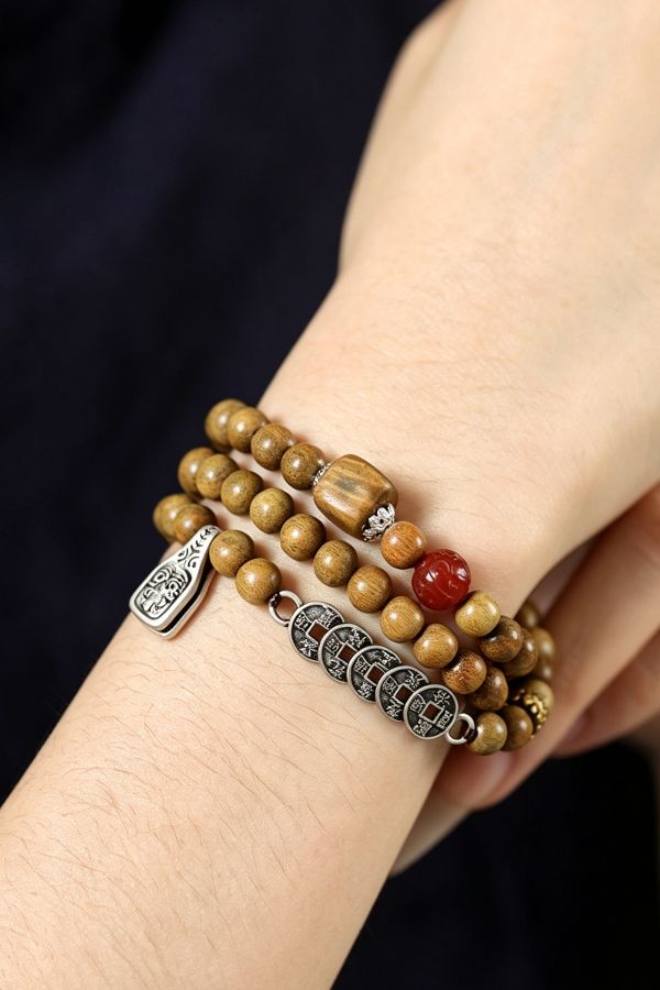 wood bead bracelet worn on wrist with red accent bead Zen Sandalwood Bracelet with Ancient Charm - Image 4