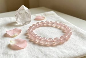 Rose Quartz Bracelet: Unconditional Love, Healing, and How to Wear It rose quartz bracelet on linen with clear quartz cluster